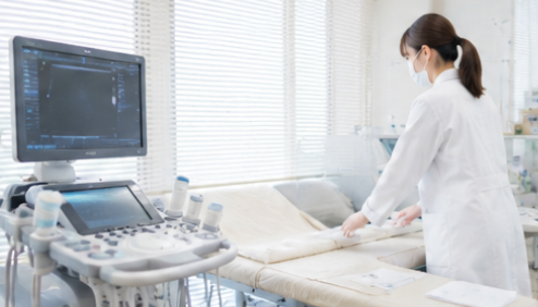 検査機器の前で業務を確認する臨床検査技師