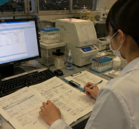 地方病院の検査室で業務記録を確認する臨床検査技師
